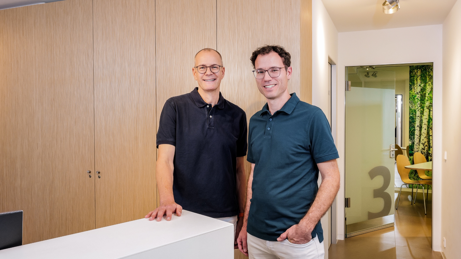 Zwei Ärzte stehen am Tresen des Empfangs ihrer Praxis